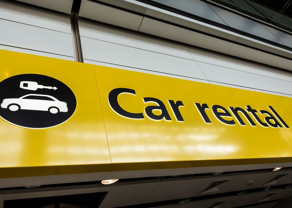 A yellow car rental sign