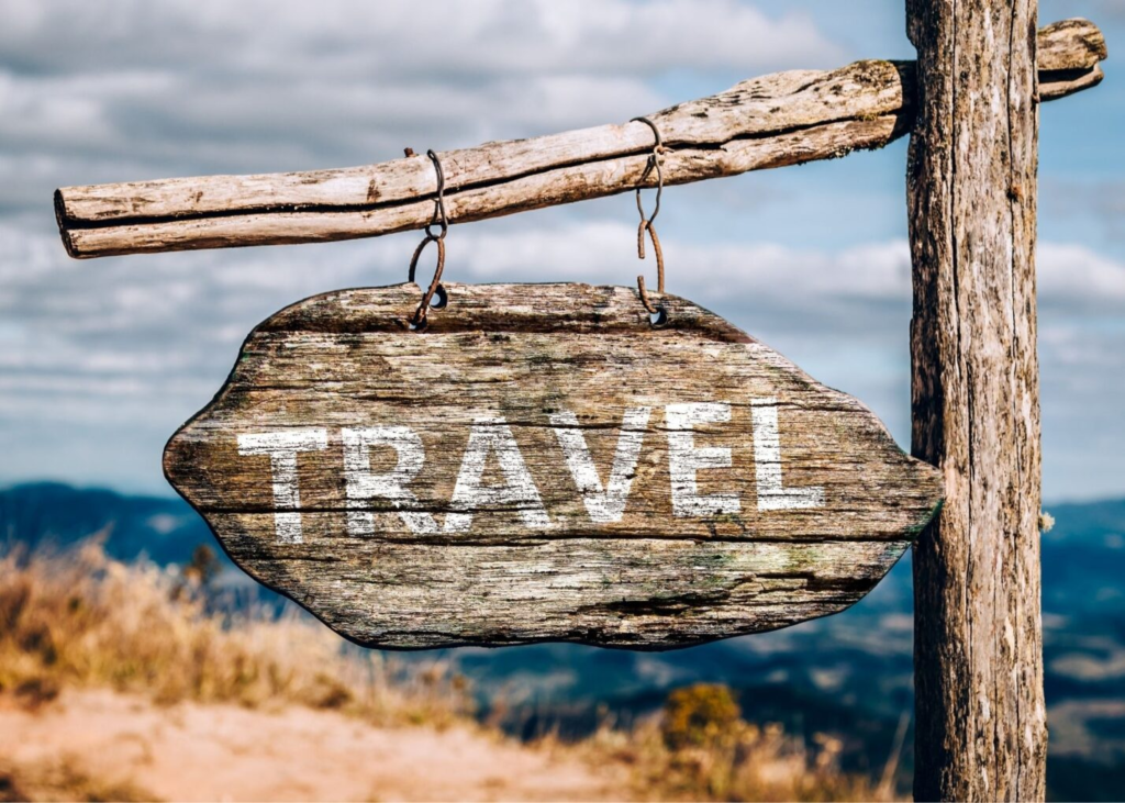 a rustic wood sign with the word "Travel" on the sign
