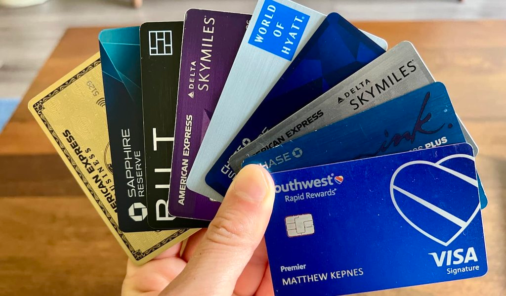 A person holding a bunch of travel credit cards