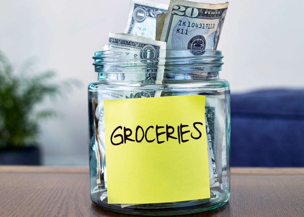 a coin jar with groceries on a sticky note